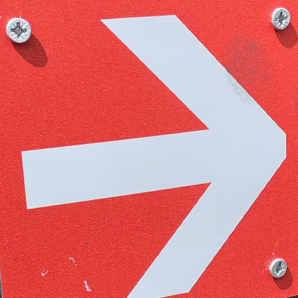 White arrow on red background
