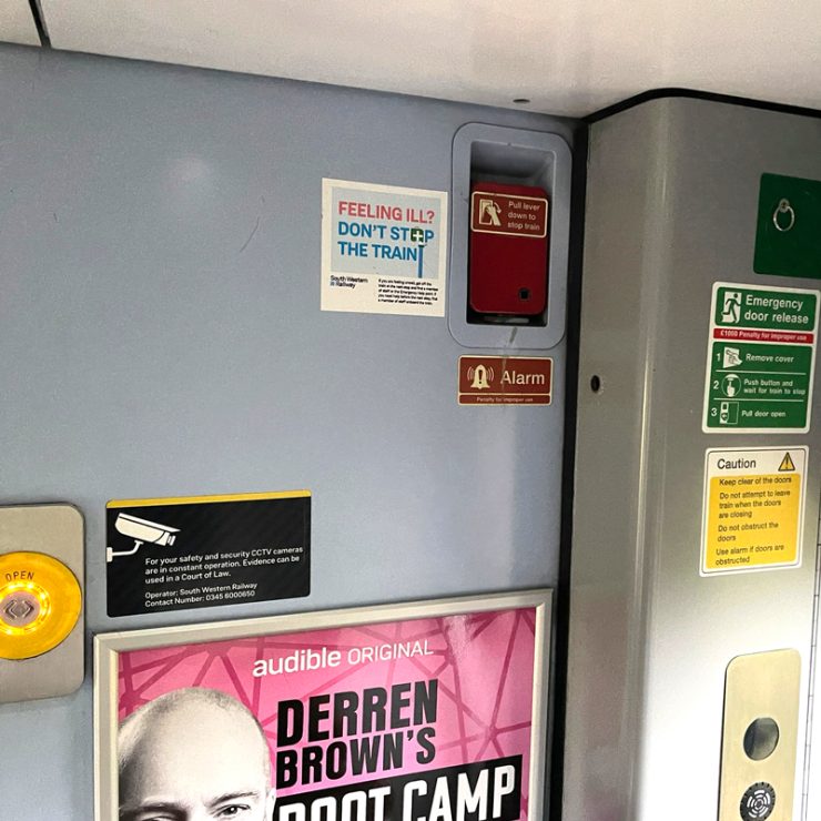The array of signage and advertising in the vestibule of a train.
