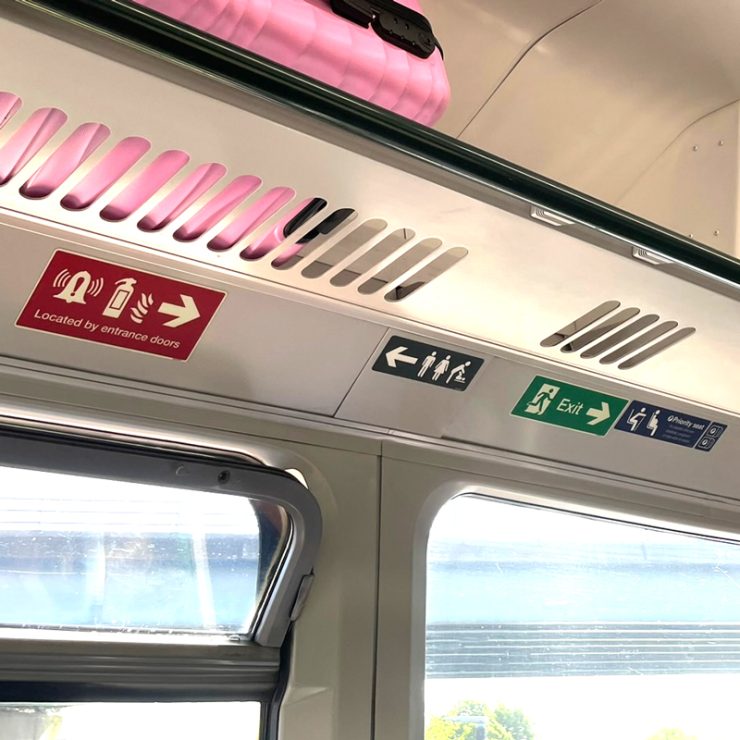 Confusing signage above the windows in a train carriage.
